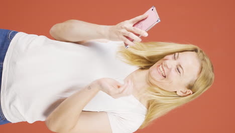 Vertical-video-of-The-woman-looking-at-the-phone-is-happy.